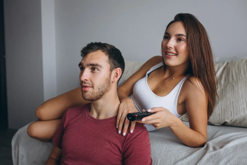Couple regardant la télévision dans un salon moderne – À propos de IPTV Quebec