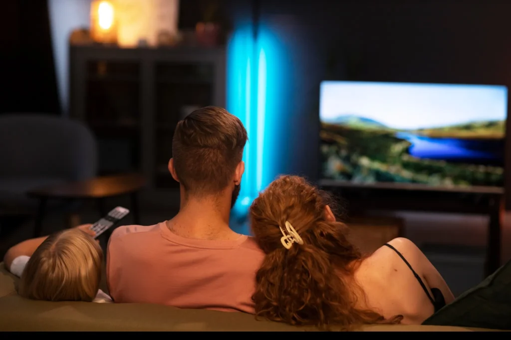 Famille réunie devant la télévision en soirée – À propos de IPTV Quebec