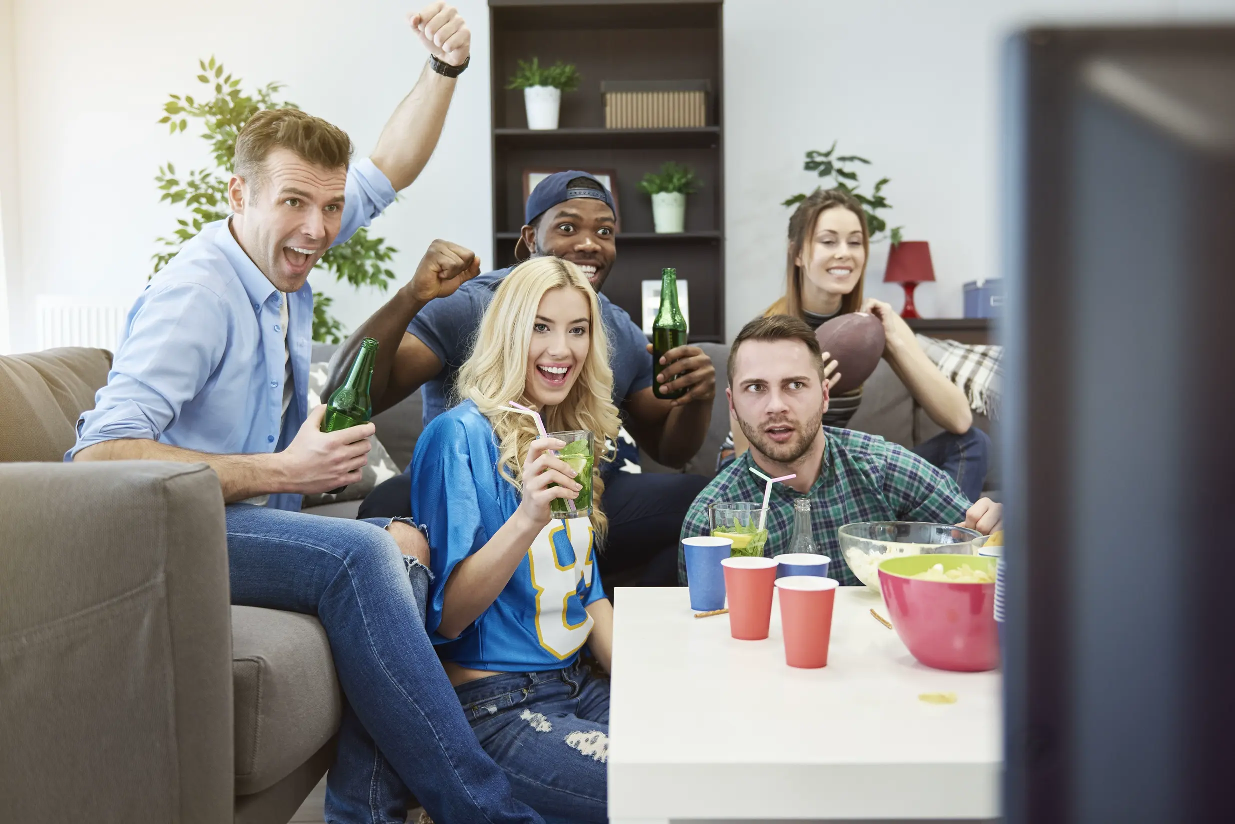 IPTV Montreal – amis regardant du sport en direct à la télévision avec enthousiasme à la maison