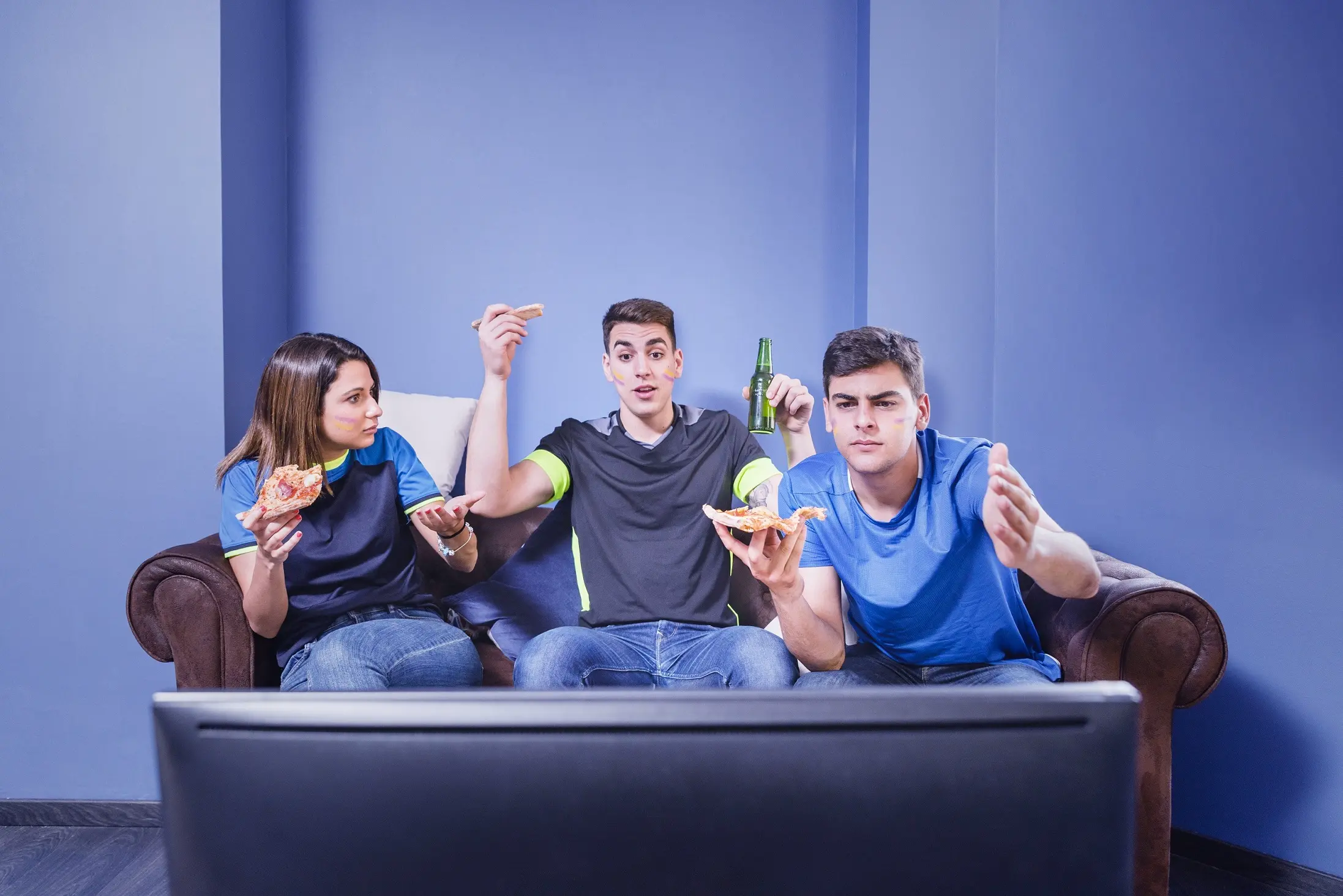 prix IPTV Quebec – groupe de jeunes regardant du sport en direct à la télévision avec émotions à la maison