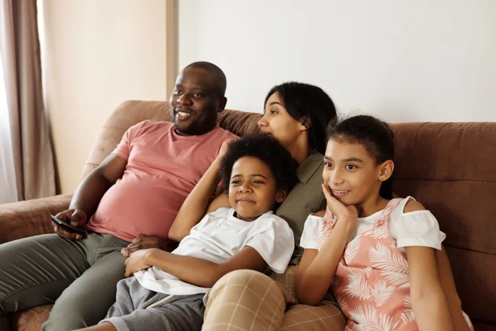 Famille réunie sur un canapé pour regarder la télévision